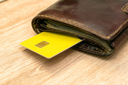 a credit card sticks out of a wallet lying on the copyscape table. High quality photo