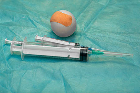 the concept of universal vaccination is a chicken egg with a Aid and different syringes on a medical napkin. High quality photoの写真素材