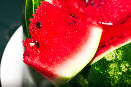 red ripe juicy watermelon with a cut off segment close-up background. High quality photoの写真素材