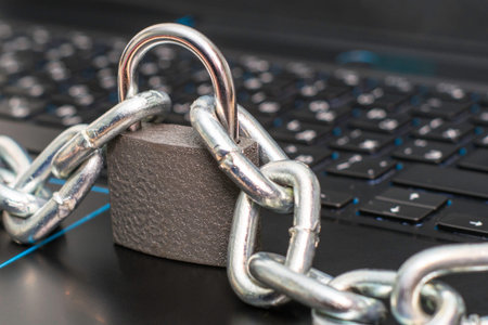an iron chain fastened with a padlock on a computer keyboard the concept of data protection...