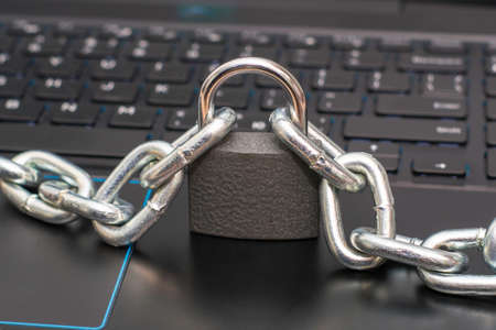 an iron chain fastened with a padlock on a computer keyboard the concept of data protection censorship on the Internet. High quality photoの写真素材