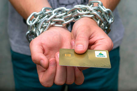 07.29.2021 Divnoye Stavropol Territory Russia the golden refueling card of the YUKOS company in the hands of a man chained in an iron chainのeditorial素材