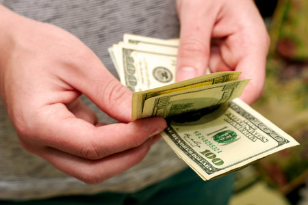 a man counts money a bundle of hundred dollar bills. High quality photo
