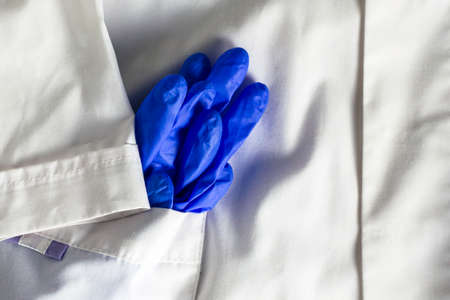 blue rubber medical protective gloves in the side pocket of a white medical coat. High quality photoの写真素材