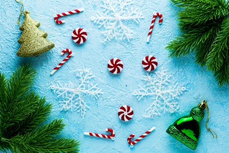 new Year's Christmas background on a blue surface fir twigs snowflakes candies and decorations. High...