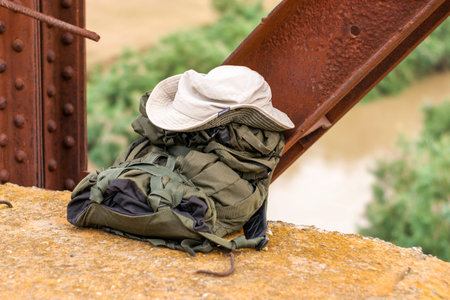 backpack and hat of a tourist on a bridge with a view of the river concept tourism travel. High...