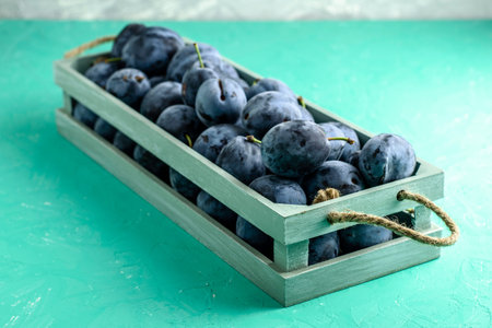 freshly picked ripe plums in a vintage box. High quality photo