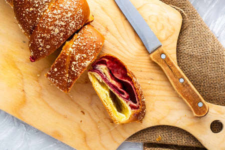 sliced cherry-vanilla strudel on a wooden cutting board next to a knife. High quality photoの写真素材
