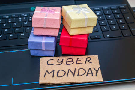 boxes with gifts on the laptop keyboard next to a sign with the inscription cyber Monday. High quality photoの写真素材