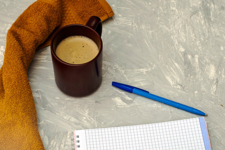 a cup of cappuccino coffee a notepad and a fountain pen on a gray surface. High quality photoの写真素材