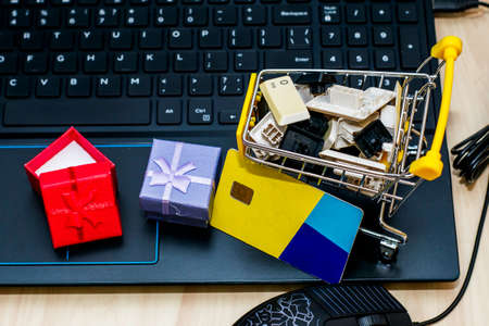 on the keyboard shopping cart with keyboard keys gift boxes and credit card concept cyber monday. High quality photoの写真素材