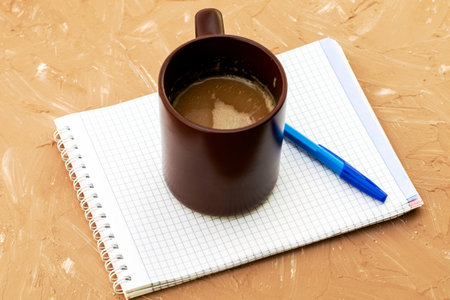 a cup of coffee cappuccino coffee grinder notepad and fountain pen on a gray surface. High quality...