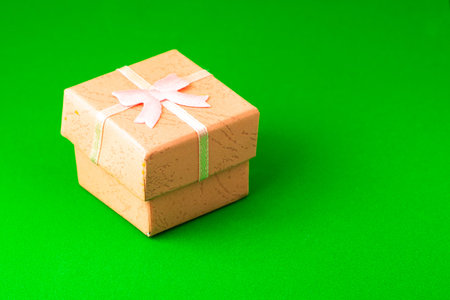 pink gift box on a green background with copyspace. High quality photo