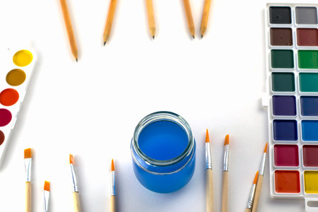 watercolor paints brushes a jar of water and pencils on a white background copyscape. High quality...