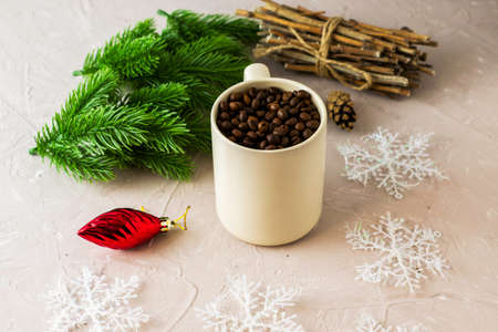 a mug with coffee beans fir twigs a bundle of brushwood pine cones Christmas decorations and snowflakes. High quality photoの写真素材