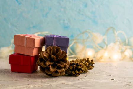 gift boxes on a New Year's background with a garland and pine cones with copyscape. High quality photoの写真素材