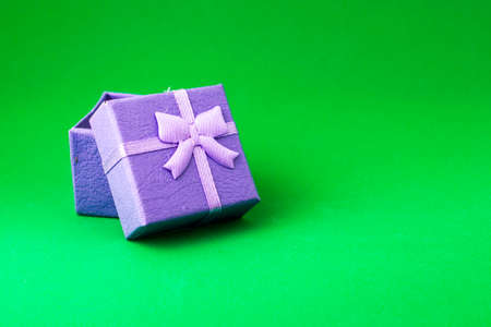 blue gift box with an open lid on a green background with copyspace. High quality photoの写真素材