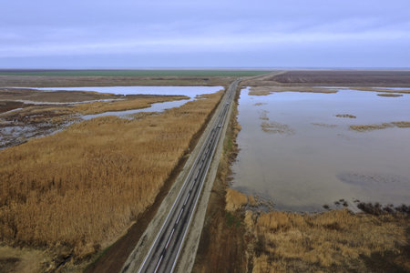 asphalt road and bridge over a lake in the steppe photo from a quadcopter landscape. high quality...