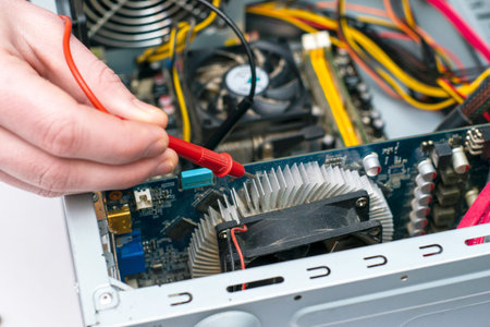 the master repairs the old computer checks the chips with a multimeter. high quality photo