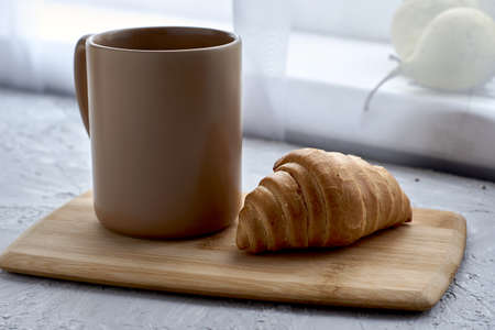 coffee mug and croissant on cutting board. high quality photoの写真素材