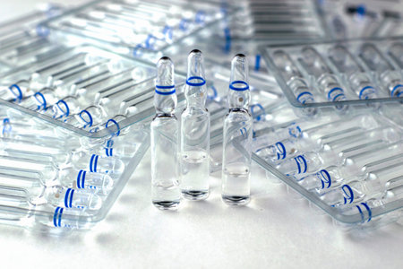 plastic transparent containers with glass ampoules and separate ampoules on a white background. high...
