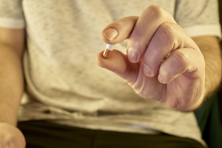 a man holds a pill in his hand in front of him. high quality photo