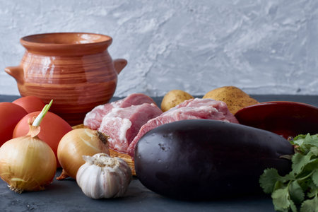pots for cooking chanakhi and ingredients meat tomatoes potatoes garlic eggplant on the table. high quality photoの写真素材