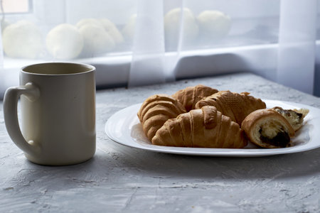 a plate of croissants and a cup of coffee on the table. high quality photoの写真素材