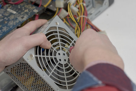 the master repairs the computer's power supply unit unscrews the screw with a screwdriver. high quality photoの写真素材