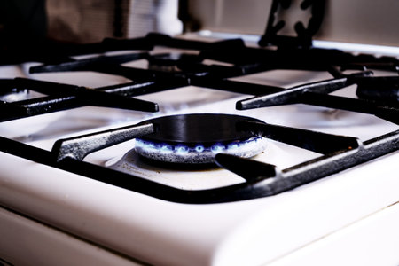a burning gas stove on a white kitchen stove. high quality photo