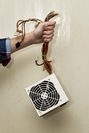 computer power supply unit with wires in the repairman's hand. high quality photo