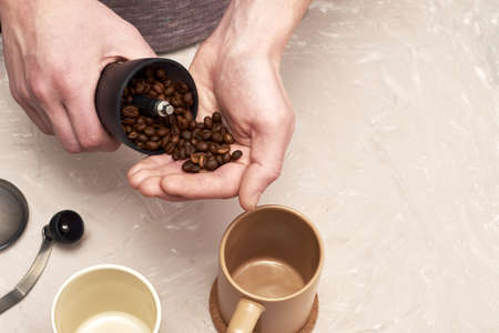 a person prepares coffee and puts coffee beans into a coffee grinder. high quality photoの写真素材