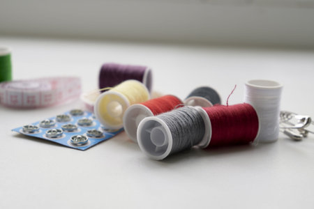 sewing kit thread needles pins and measuring tape on the table. high quality photo
