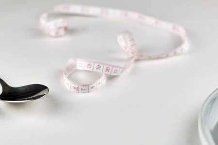 spoon centimeter and plate on a light background with a copy space concept nutrition diet. high quality photoの写真素材