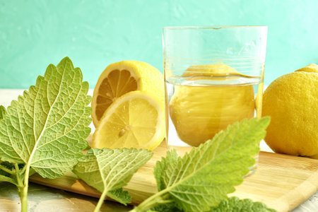 a glass of water with lemons and mint on the table. high quality photo
