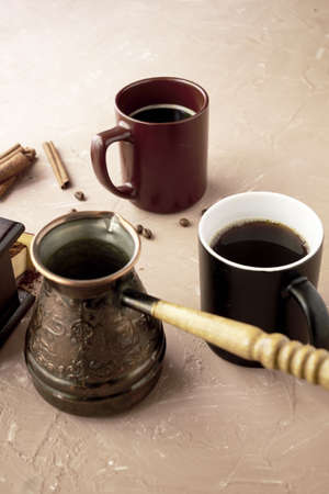 coffee grinder two mugs of cinnamon coffee beans and a turk for brewing coffee on the table. high quality photoの写真素材