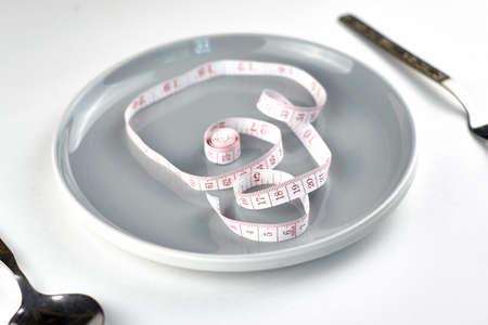 cutlery a centimeter in a plate on a light background of the concept of space nutrition diet. high quality photoの写真素材