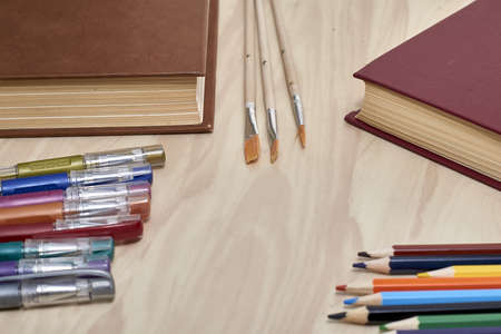 books pencils fountain pens and brushes for drawing on the table concept education school. high quality photoの写真素材