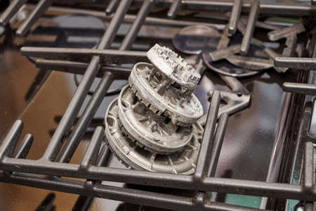 the burners removed from the gas stove lying on the table in the repair shop. high quality photoの写真素材