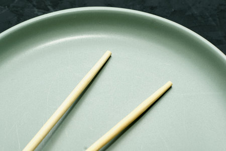 gray plate and chopsticks on a black background. high quality photoの写真素材