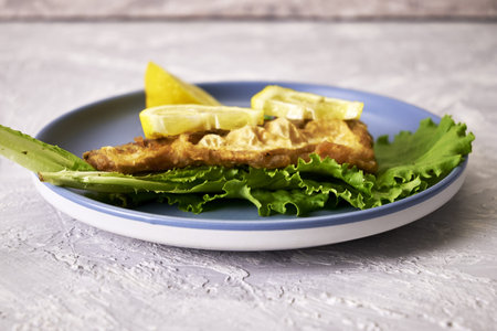 fried fish with lemon and herbs on a plate on the table. high quality photo