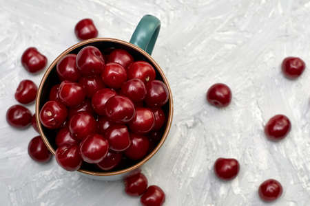 red ripe cherries in a teacup on the table. high quality photoの写真素材