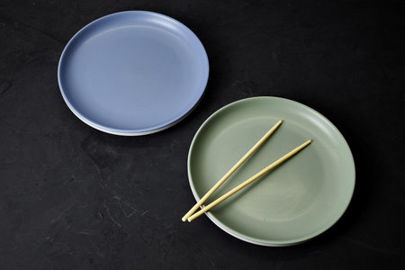 two plates and chopsticks on a black background. high quality photo