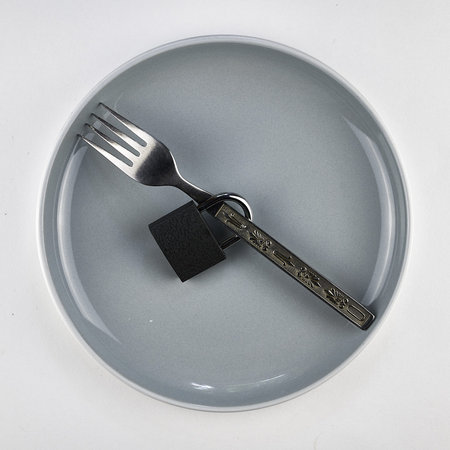 a fork with a lock on a gray plate concept dietの写真素材