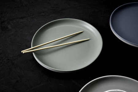 three plates and chopsticks on a black background. high quality photoの写真素材