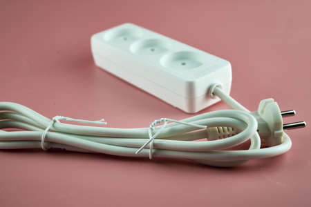 white electric extension cord on pink background. high quality photoの写真素材
