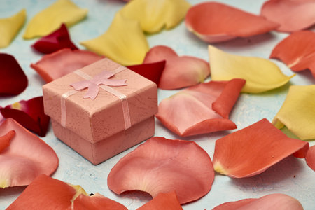 a gift box on a background of rose petals