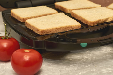 sandwich maker cheese sausage and bread on the table. high quality photo