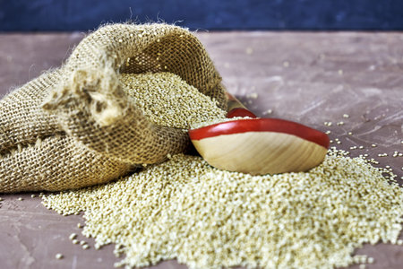 quinoa groats with a wooden spoon in a canvas bag on the table. high quality photoの写真素材