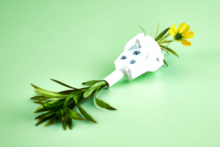 electric plug from which flowers and grass grow concept ecology clean energy. high quality photo